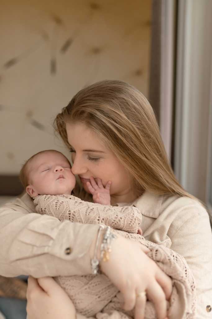 moeder met baby geposeerd in slaapkamer tijden fotosessie