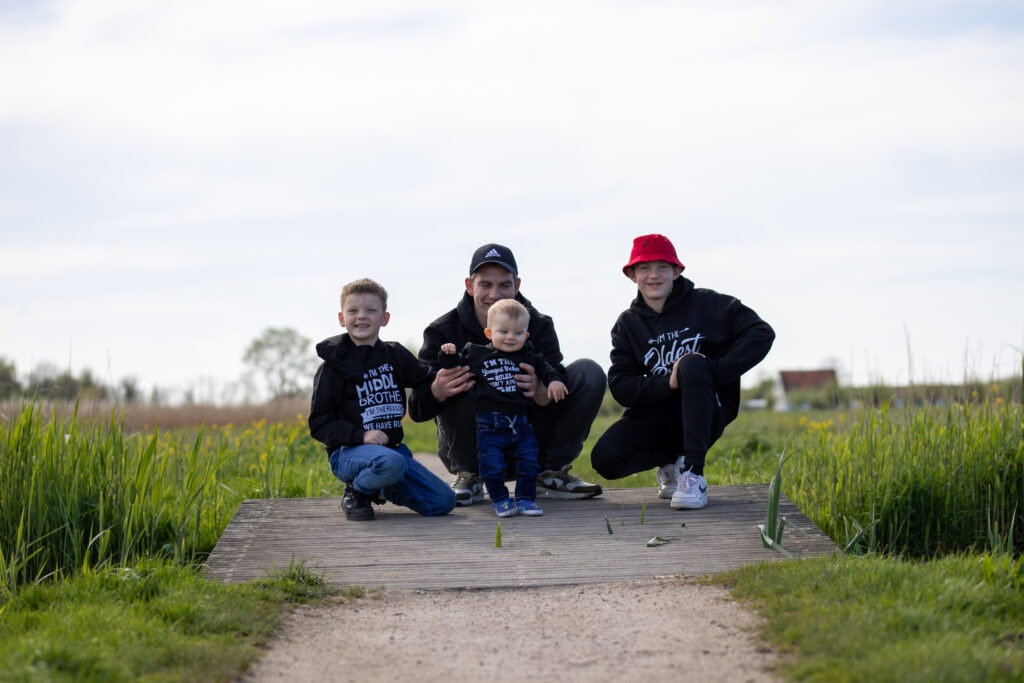 alle mannen van het gezin met een zwarte trui aan op een bruggetje in schiedam