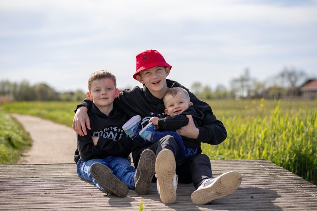 de drie zonen zitten op een bruggetje