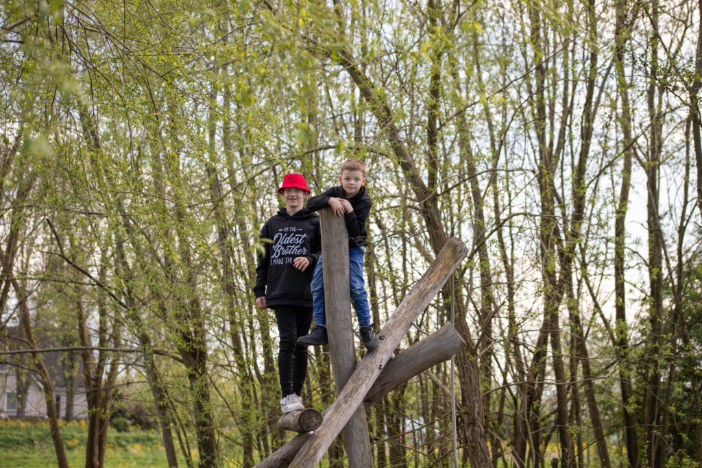 middelste en oudste zoon zijn boven op een speeltoestel geklommen in de natuurspeeltuin in Schiedam