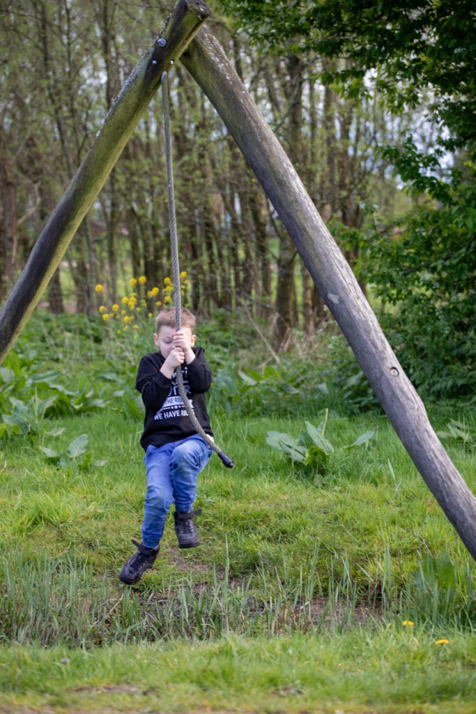 middelste zoon slingert aan een touw naar de overkant van een modderpoel