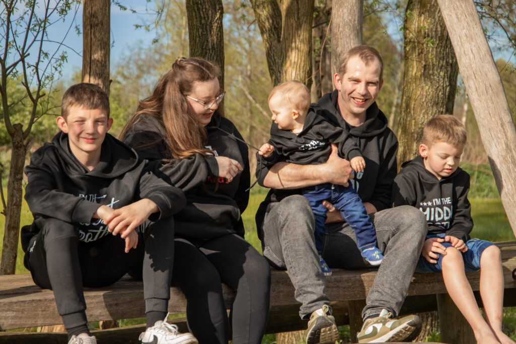 de 'baby" heeft het koortje van mama haar trui te pakken en trekt hieraan terwijl ze met zijn alle zitten op een speeltoestel