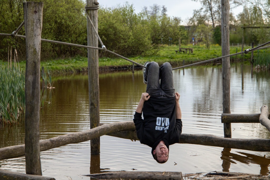 vader hangt ondersteboven aan een touw boven het water