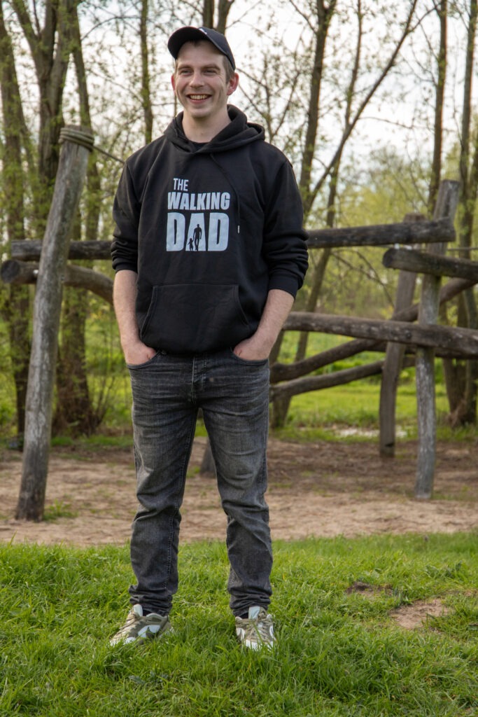 vader staat alleen op de foto met een zwarte trui aan met daarop de tekst the walking dad