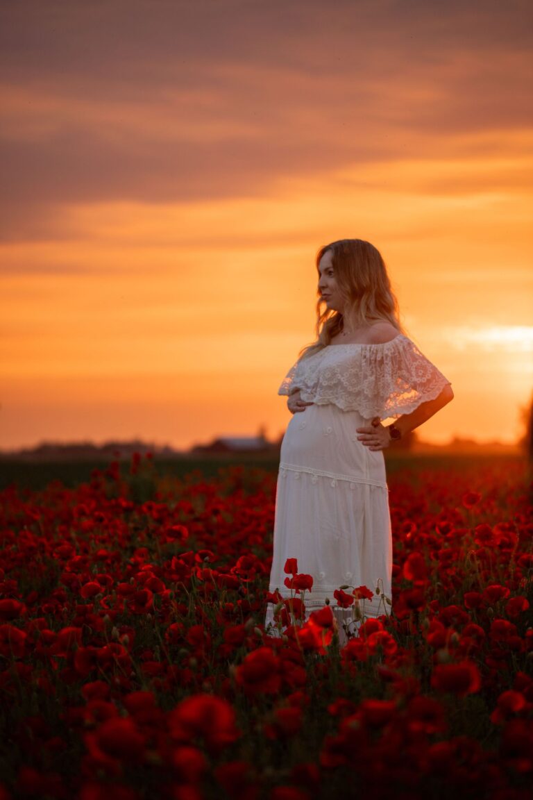 zwangere dame in witte poppy jurk met haar hand in dr zij