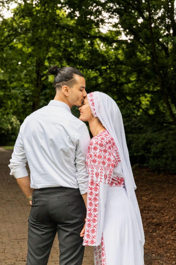 man kust vrouw op haar voorhoofd
