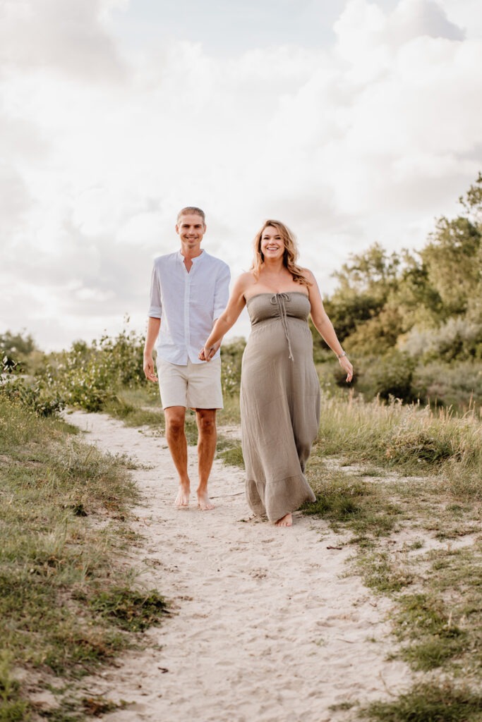 Zwangerschapsshoot Rockanje – stel hand in hand wandelend over zandpad