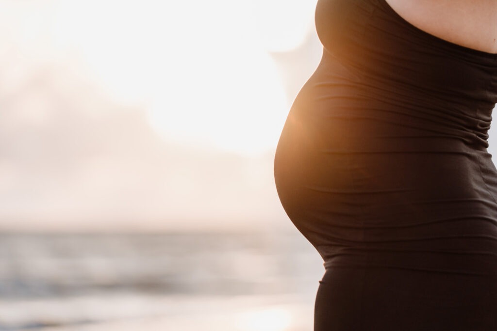 Zwangerschapsshoot Rockanje – close-up van zwangere buik in tegenlicht