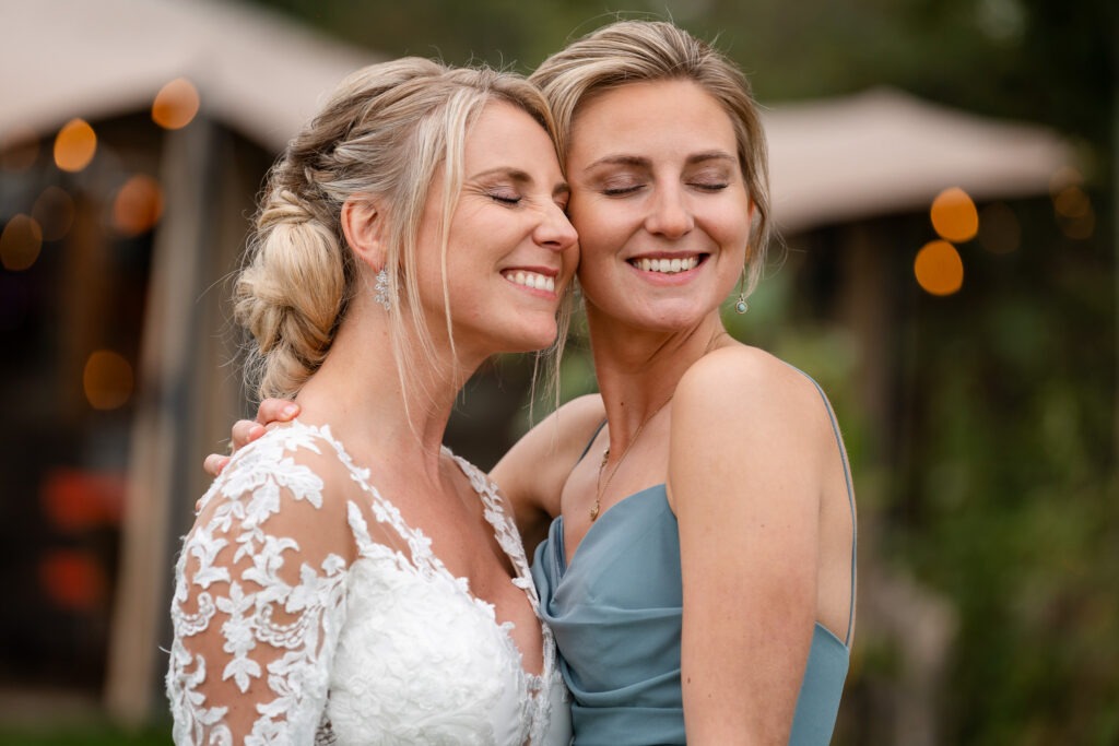 Bruid knuffelt vriendin tijdens fotoshoot De bruid en haar vriendin sluiten hun ogen en glimlachen terwijl ze elkaar omhelzen — een teder moment vol vriendschap.