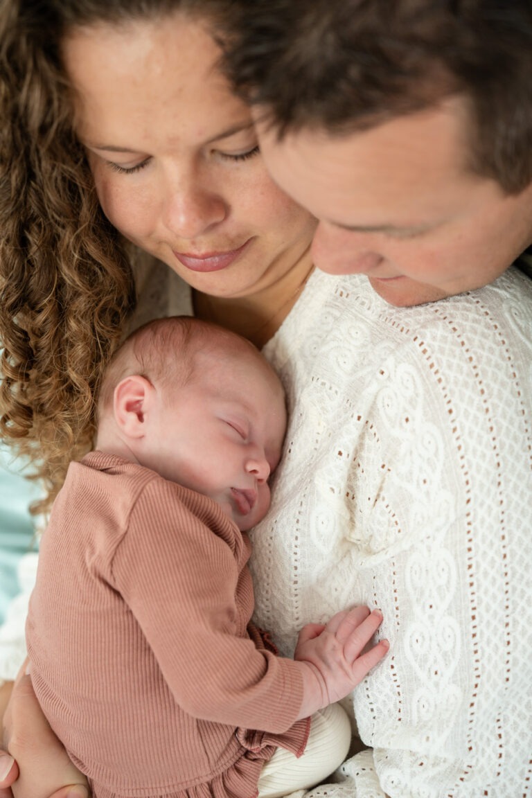 Evi viel tijdens de newbornshoot in slaap in mama’s armen. Een moment van totale rust en geborgenheid.