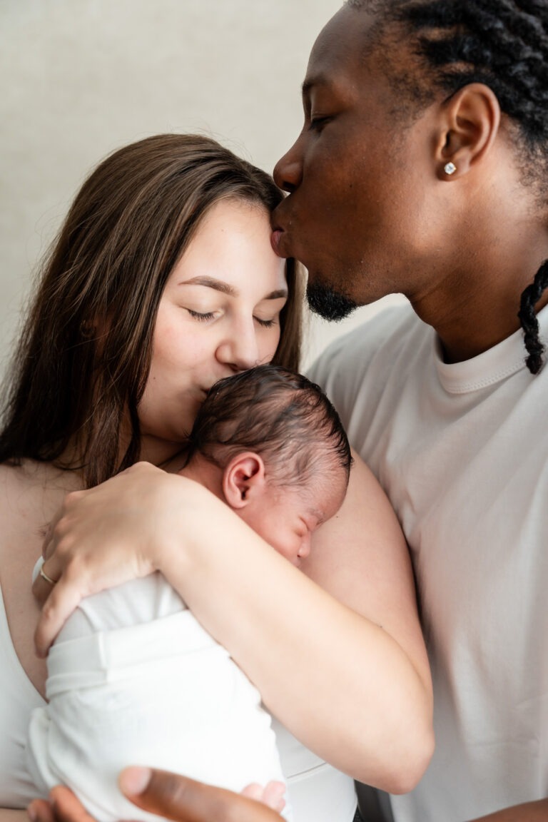 Ouders knuffelen hun pasgeboren kindje samen, vol rust en liefde – newbornshoot in Spijkenisse.