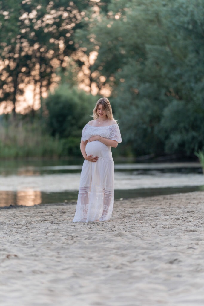 Koppel met twee hondjes tijdens zwangerschap fotoshoot aan het water