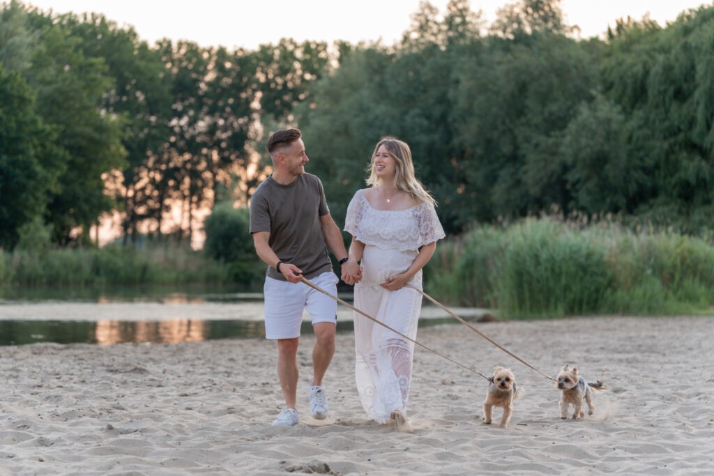 Detail van handen op buik en zachte jurk in gouden licht