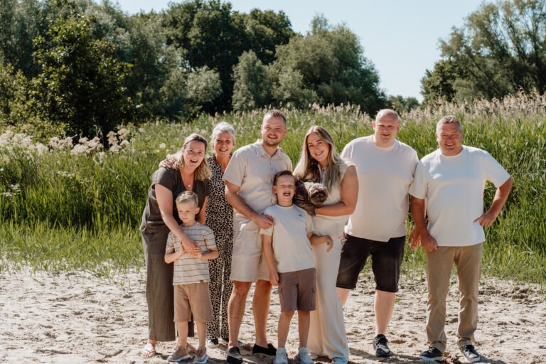 De hele familie op het strand lachend in de zon tijdens familie shoot in Zuidland