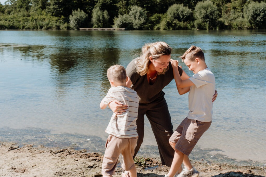 Moeder speelt met haar kinderen aan het water bij familie shoot in Zuidland