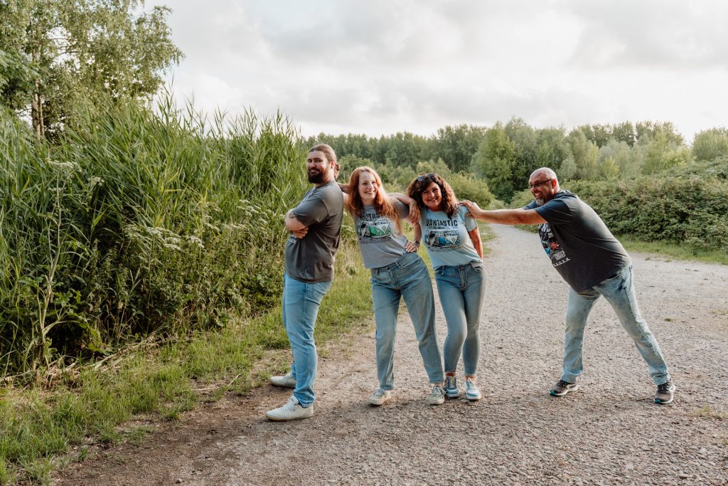 Speelse groepsfoto met een knipoog in het bos tijdens een familieshoot in de Broekpolder in Vlaardingen.