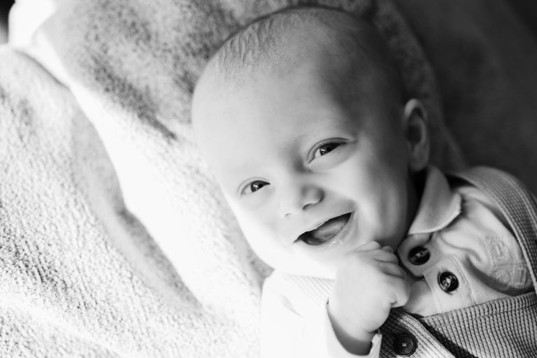 Lifestyle newbornshoot in Zuidland van een lachende baby van 3 maanden oud.