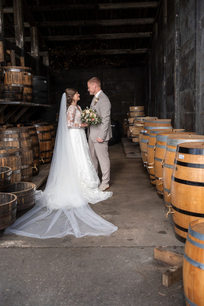 pas getrouwd stel poseert tussen de wijnvaten