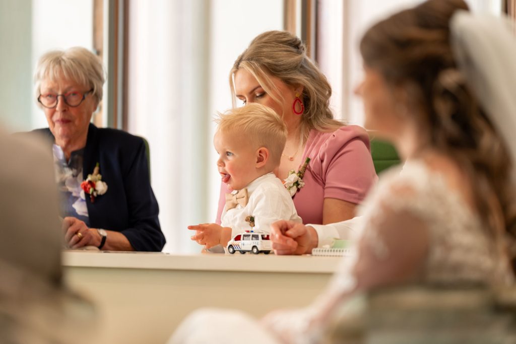 klein kind zit met autotjes te spelen tijden ceromonie bruiloft
