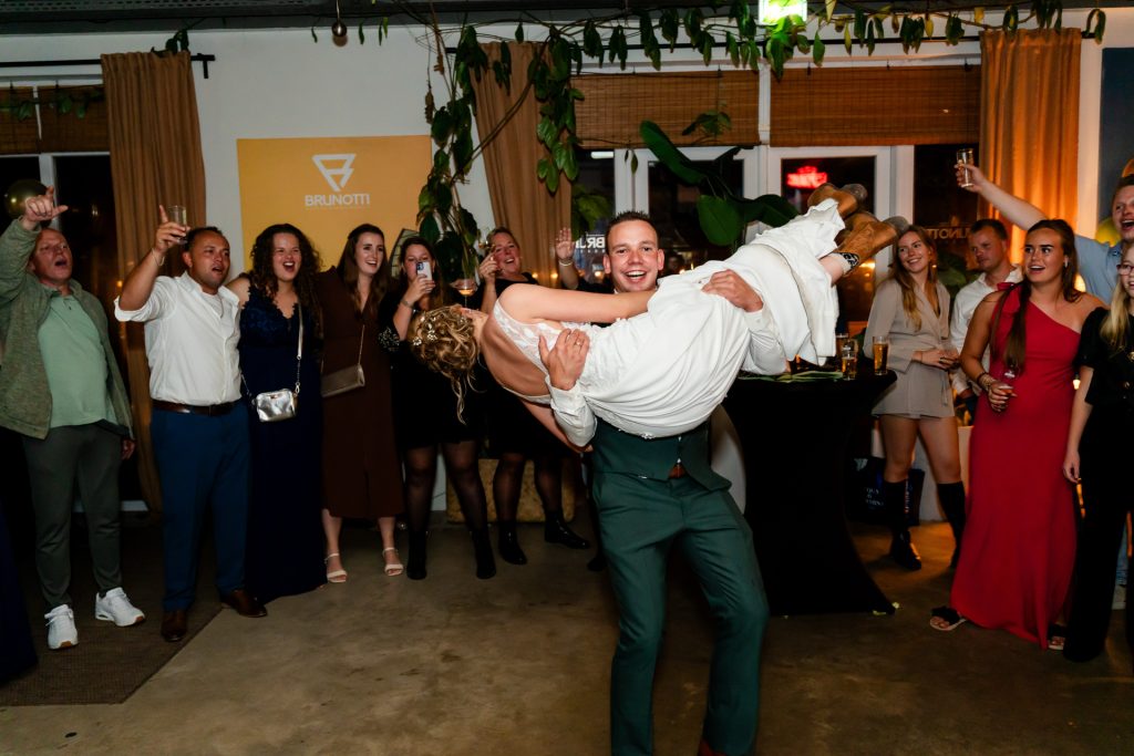 De bruid wordt op handen gedragen tijdens het trouwfeest in Oostvoorne.