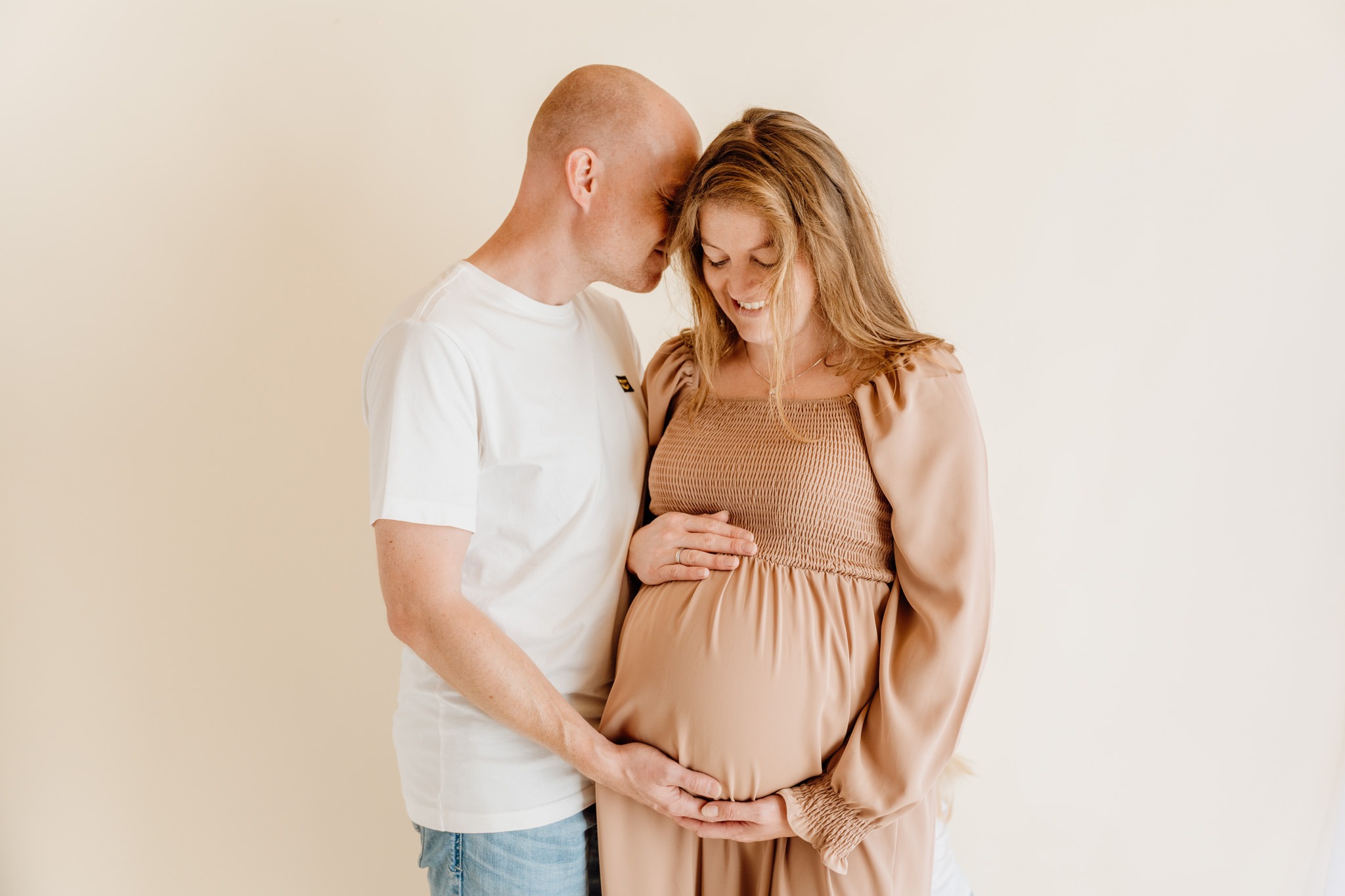 Koppel tijdens zwangerschapsshoot met zichtbare babybuik als onderdeel van een zwangerschap newbornshoot traject