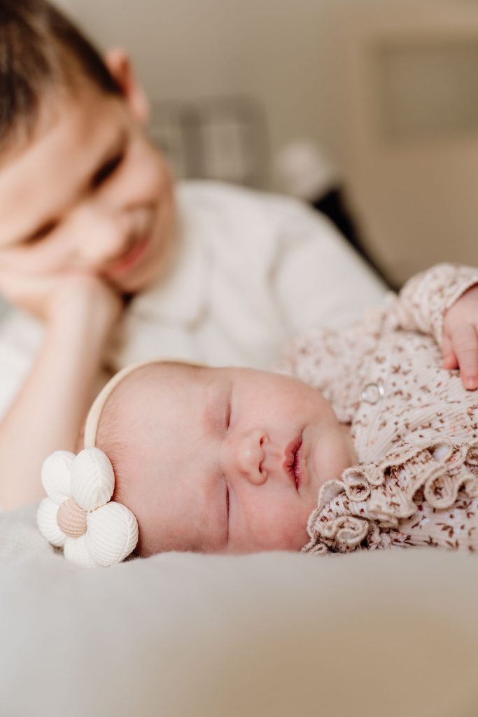 Close-up van het slapende gezichtje van newborn Yara-Nove met haar kleine vuistje naast haar wang, vastgelegd tijdens een newborn fotoshoot thuis in Zuidland.