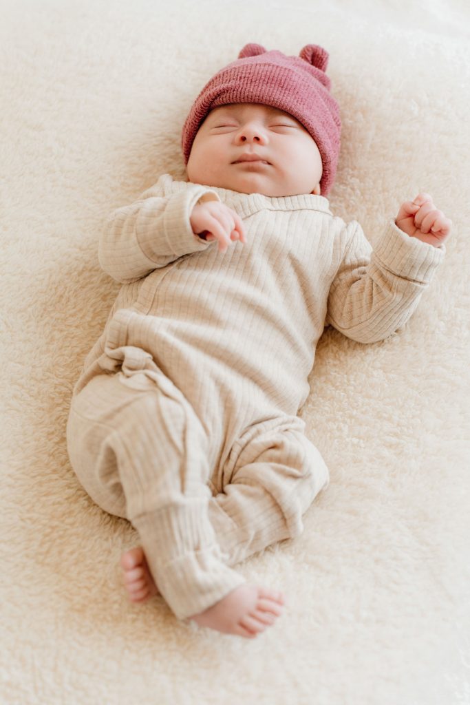 Baby Ziva liggend in een zachte outfit tijdens de newbornshoot in de studio in Zuidland, gefotografeerd door Daphne's Fotografie