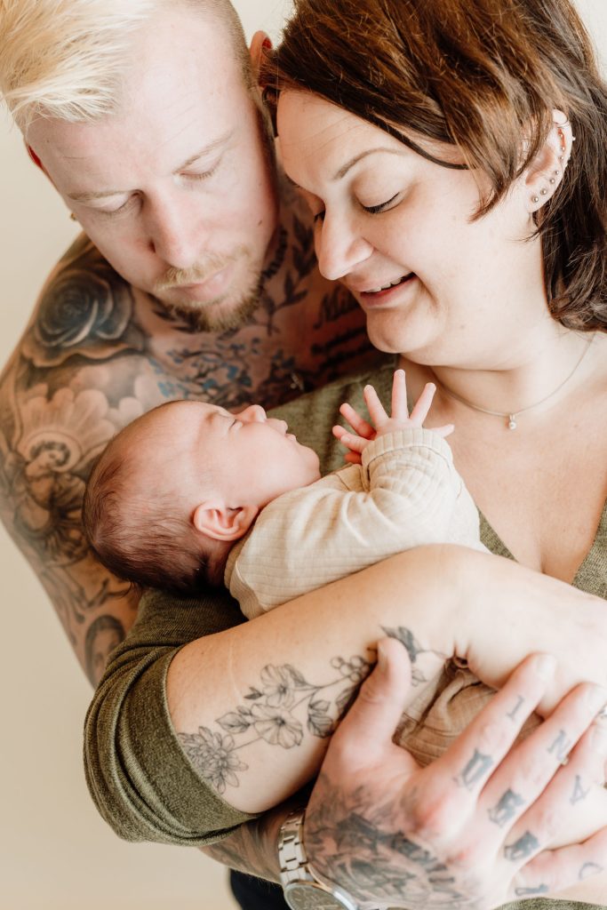Sanne, Mike en baby Ziva samen tijdens hun newbornshoot in de thuisstudio van Daphne's Fotografie in Zuidland, een warm en liefdevol familieportret