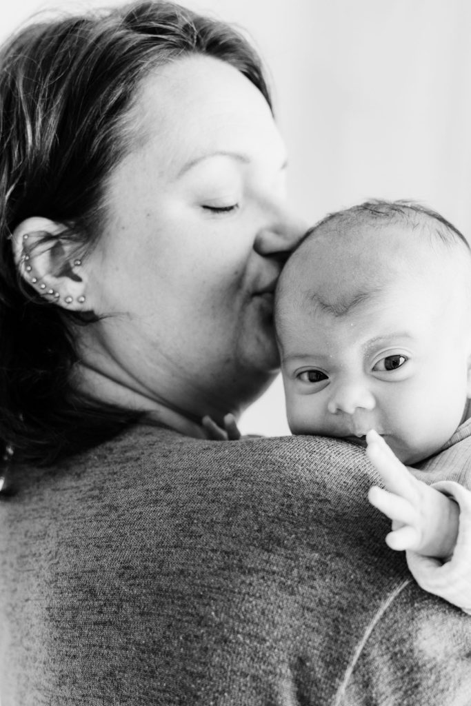 Sanne en Mike knuffelen samen baby Ziva tijdens de newbornshoot in Zuidland, een intiem en warm moment vastgelegd door Daphne's Fotografie