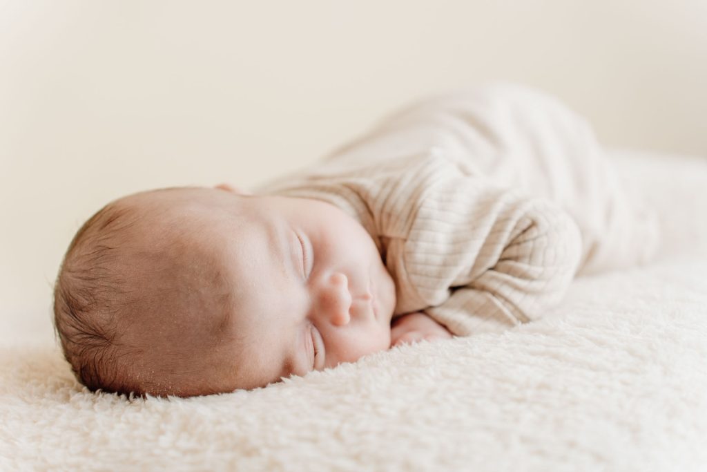 Slapende baby Ziva liggend tijdens de newbornshoot in de daglichtstudio in Zuidland, zacht en natuurlijk licht geeft de foto een warme sfeer