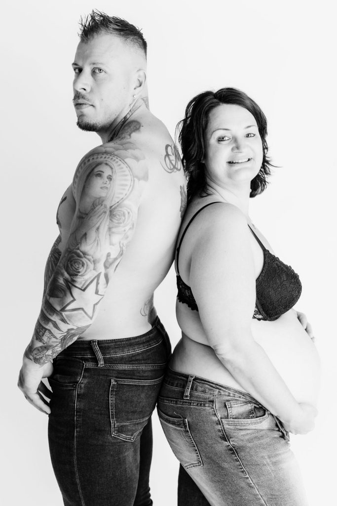 Zwart-wit rug-aan-rug portret van Sanne en Mike in de studio in Zuidland, de tatoeages op de rug van Mike komen prachtig tot hun recht