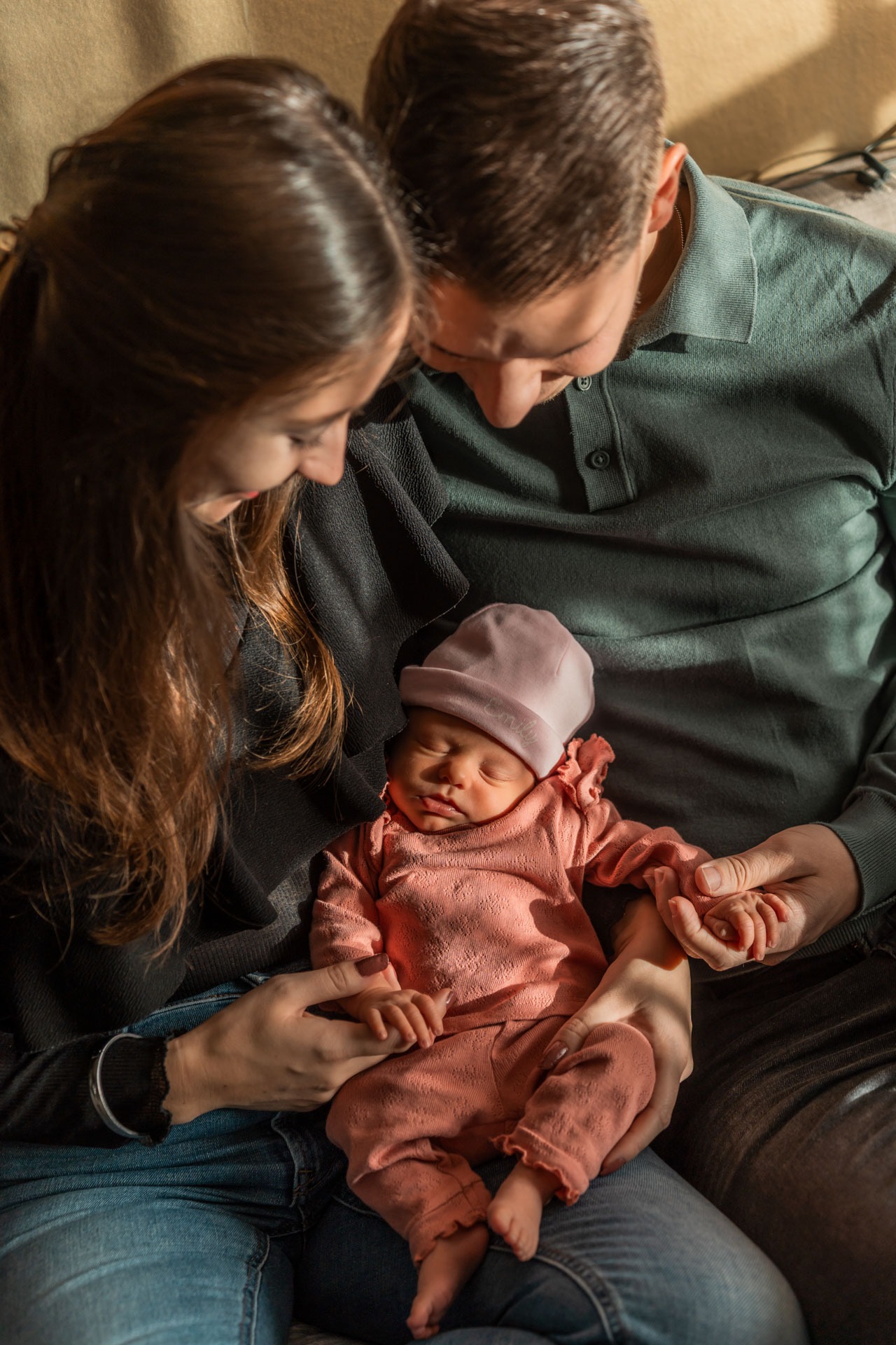 Newborn fotoshoot in Zuidland, papa en mama met baby op de bank