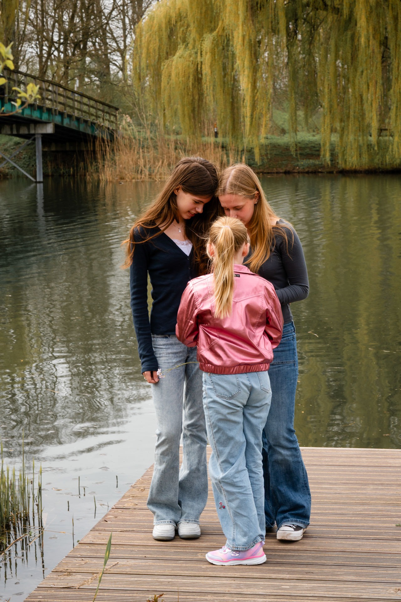 Familieleden dicht bij elkaar aan de waterkant tijdens familieshoot bij de Bernisse in Abbenbroek