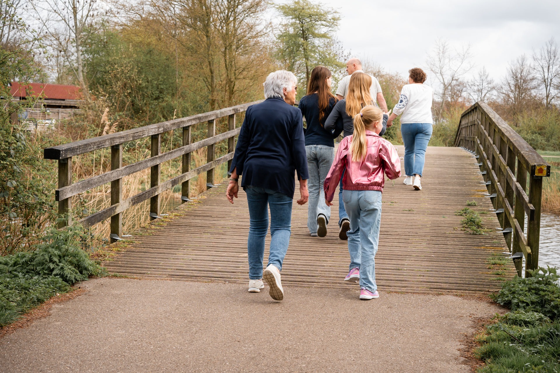 Familie steekt samen een houten brug over tijdens familieshoot bij de Bernisse in Abbenbroek