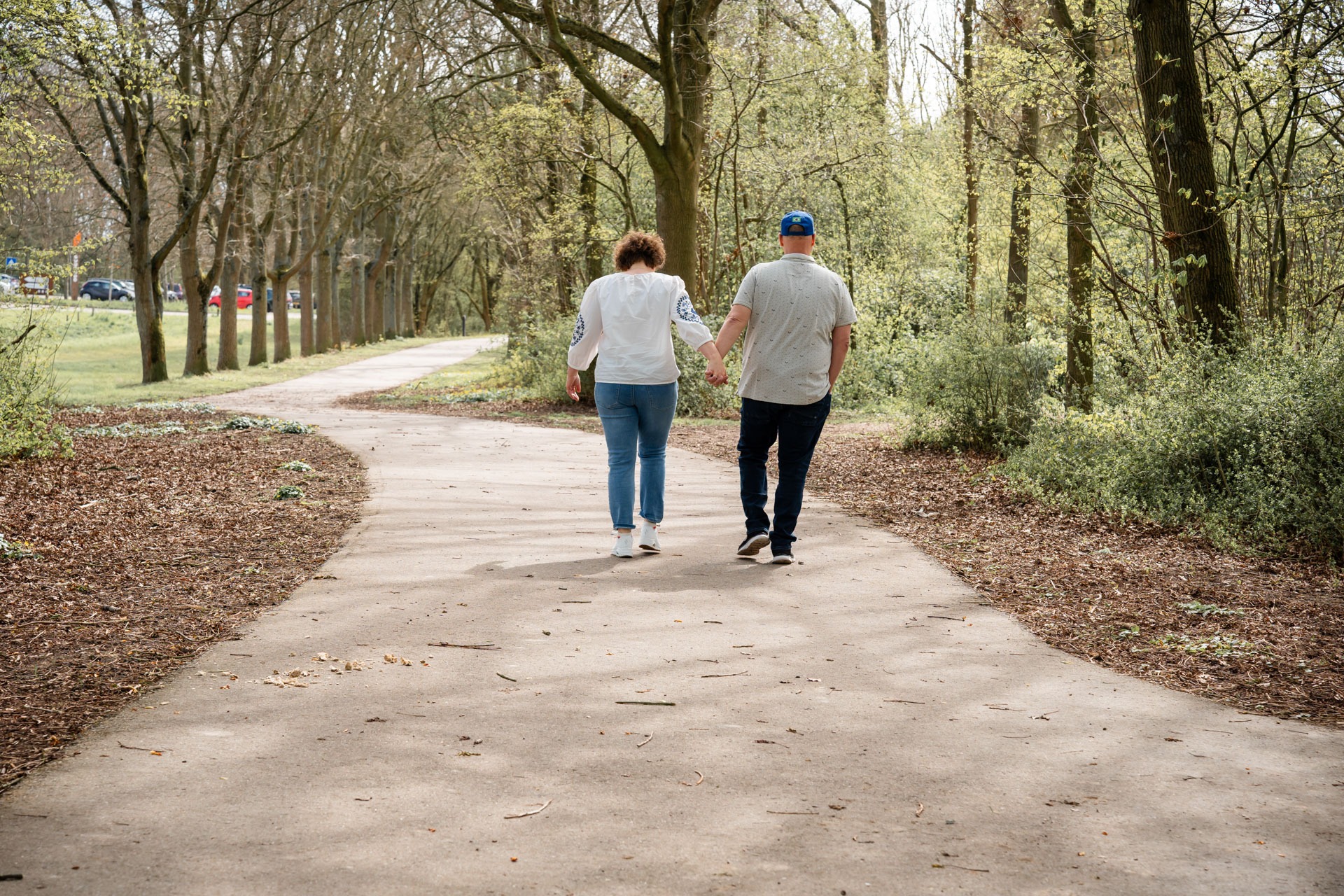 Twee familieleden wandelen samen over een bospad tijdens familieshoot bij de Bernisse