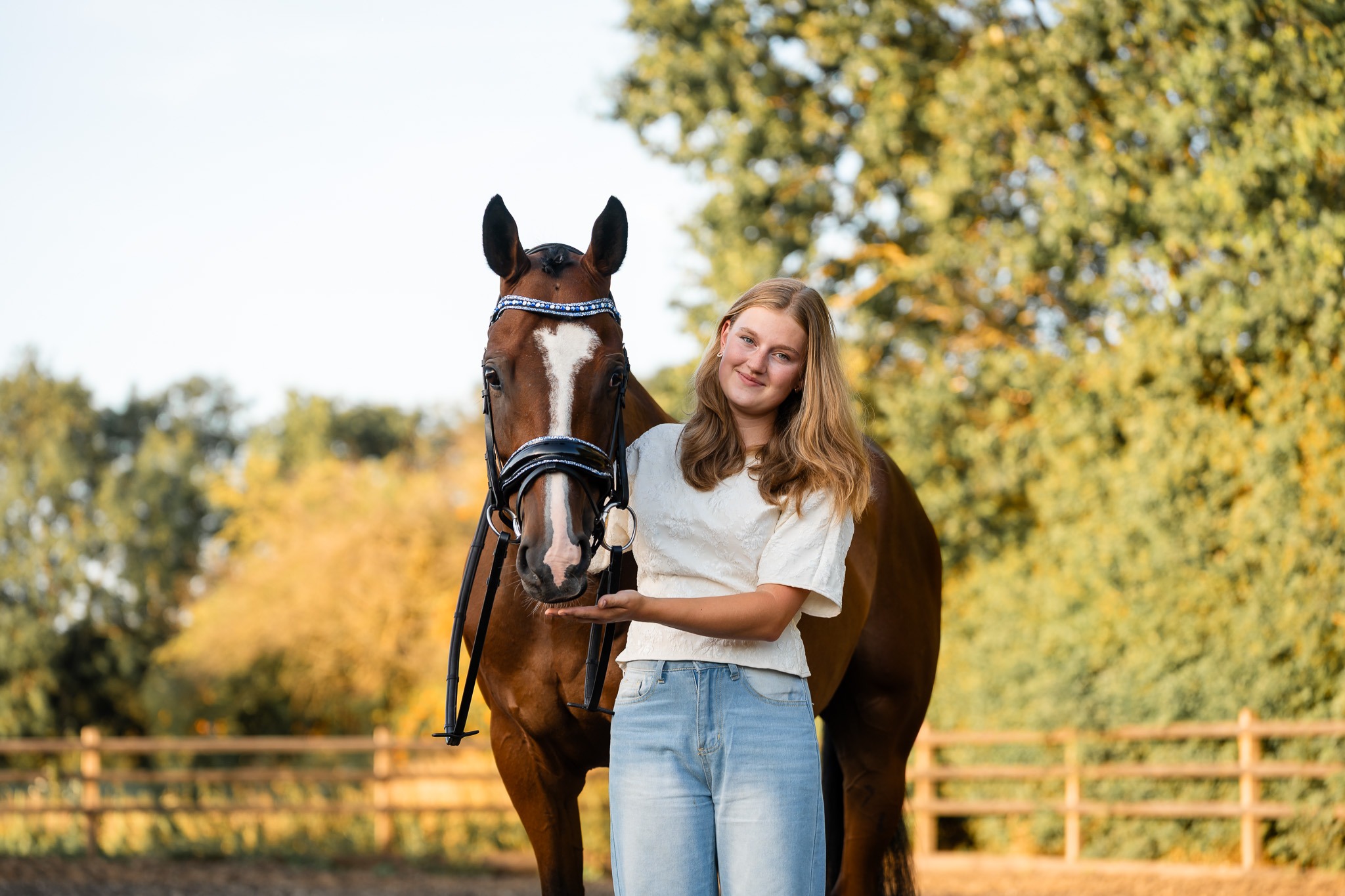 Meisje en haar bruine paard staan samen op de manege in Tinte